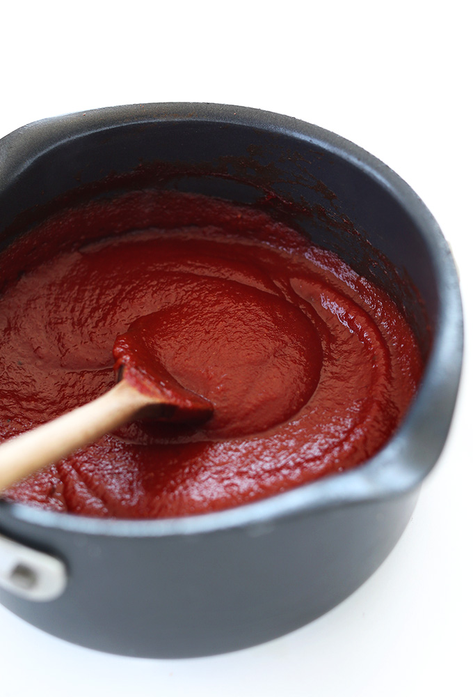 Using a wooden spoon to stir a batch of homemade ketchup