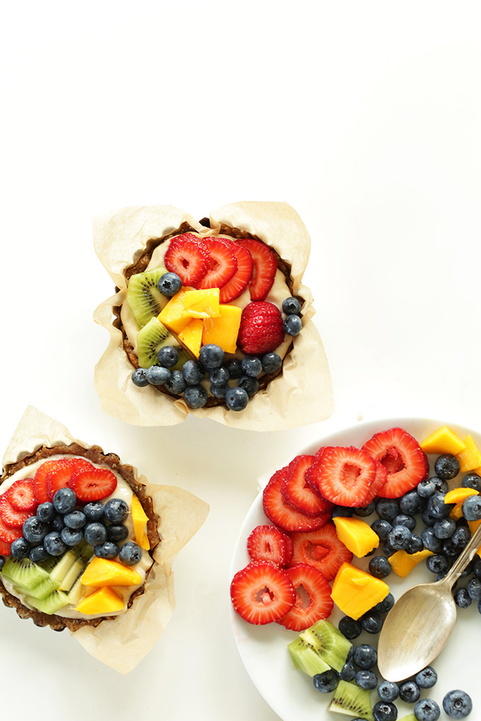 7-ingredient Lemon Cookie Fruit Tarts and a plate of fresh fruit in a rainbow of colors