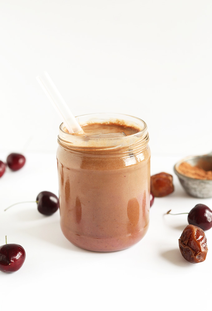 Glass jar of Chocolate Cherry Almond Milk with a straw