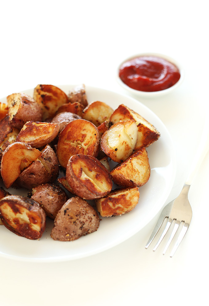 Plate of breakfast potatoes alongside a small bowl of ketchup