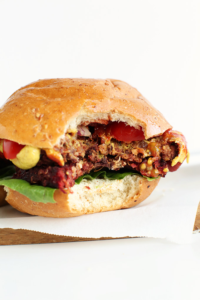 Partially eaten vegan Black Beet Burger on a bun