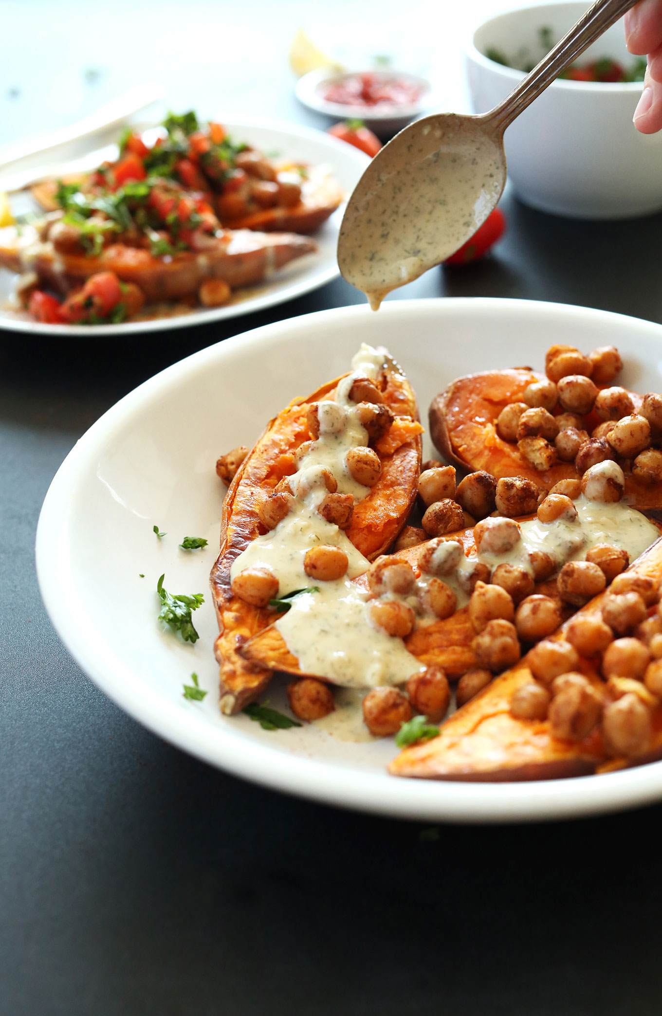 Drizzling dressing onto our Mediterranean Baked Sweet Potatoes recipe