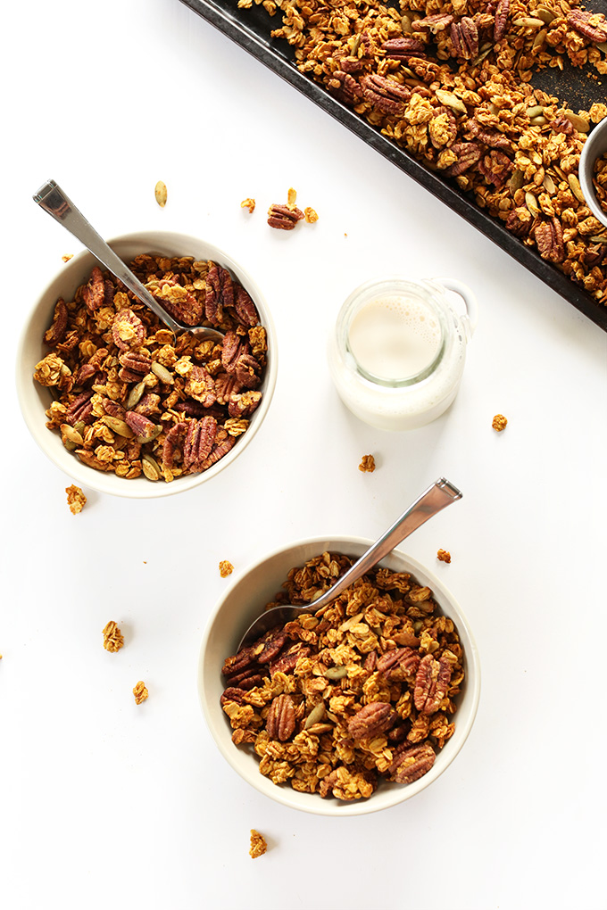 Bowls of Pumpkin Pecan Granola and a jug of nut milk for a delicious gluten-free vegan breakfast