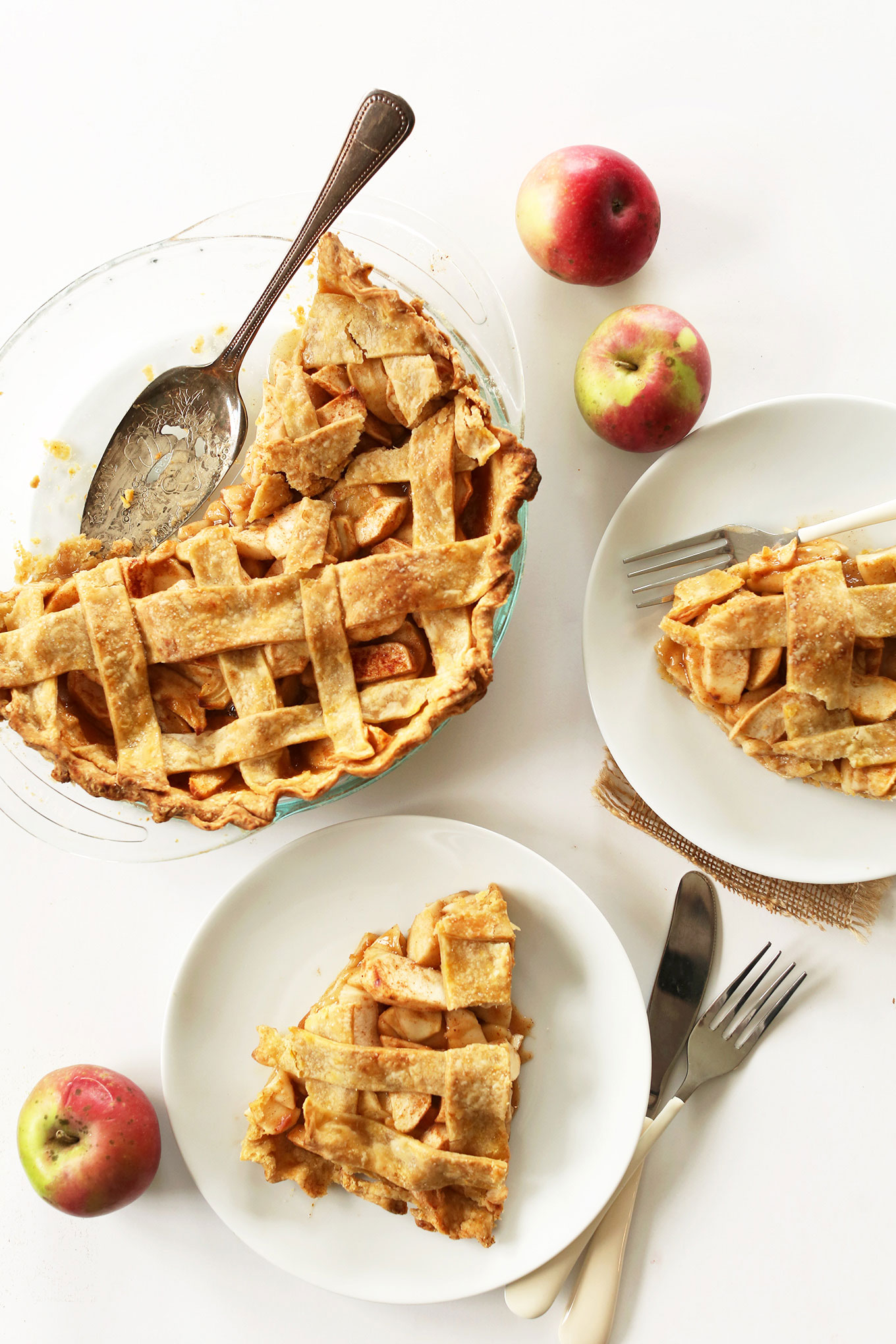 Plates with slices of vegan apple pie alongside the rest of the pie