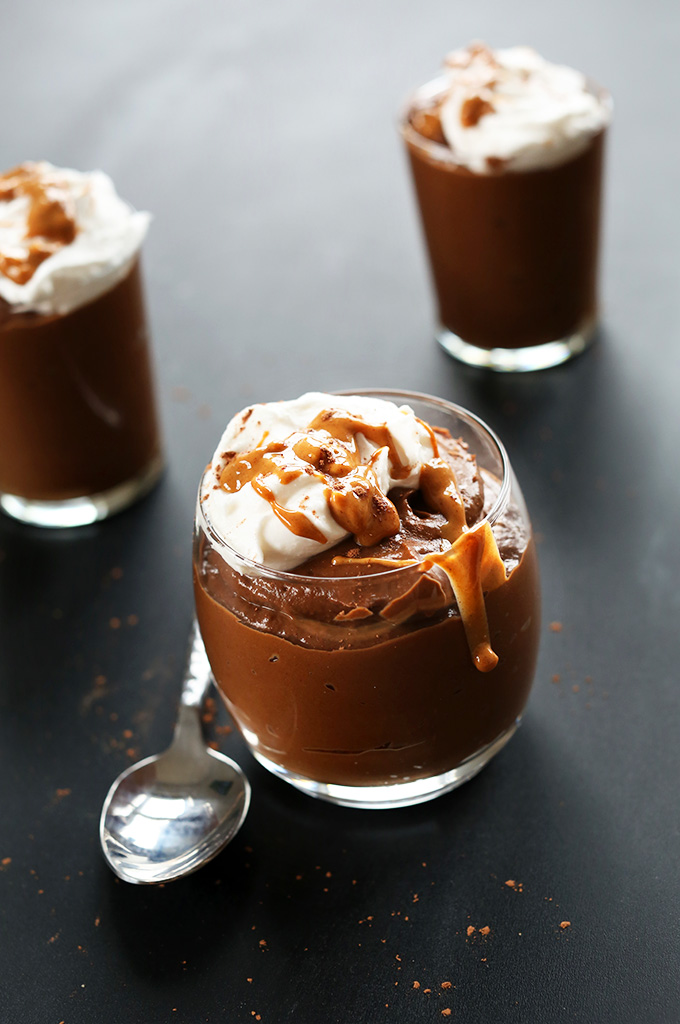 Glass jars of Chocolate PB Avocado Pudding with coconut whipped cream