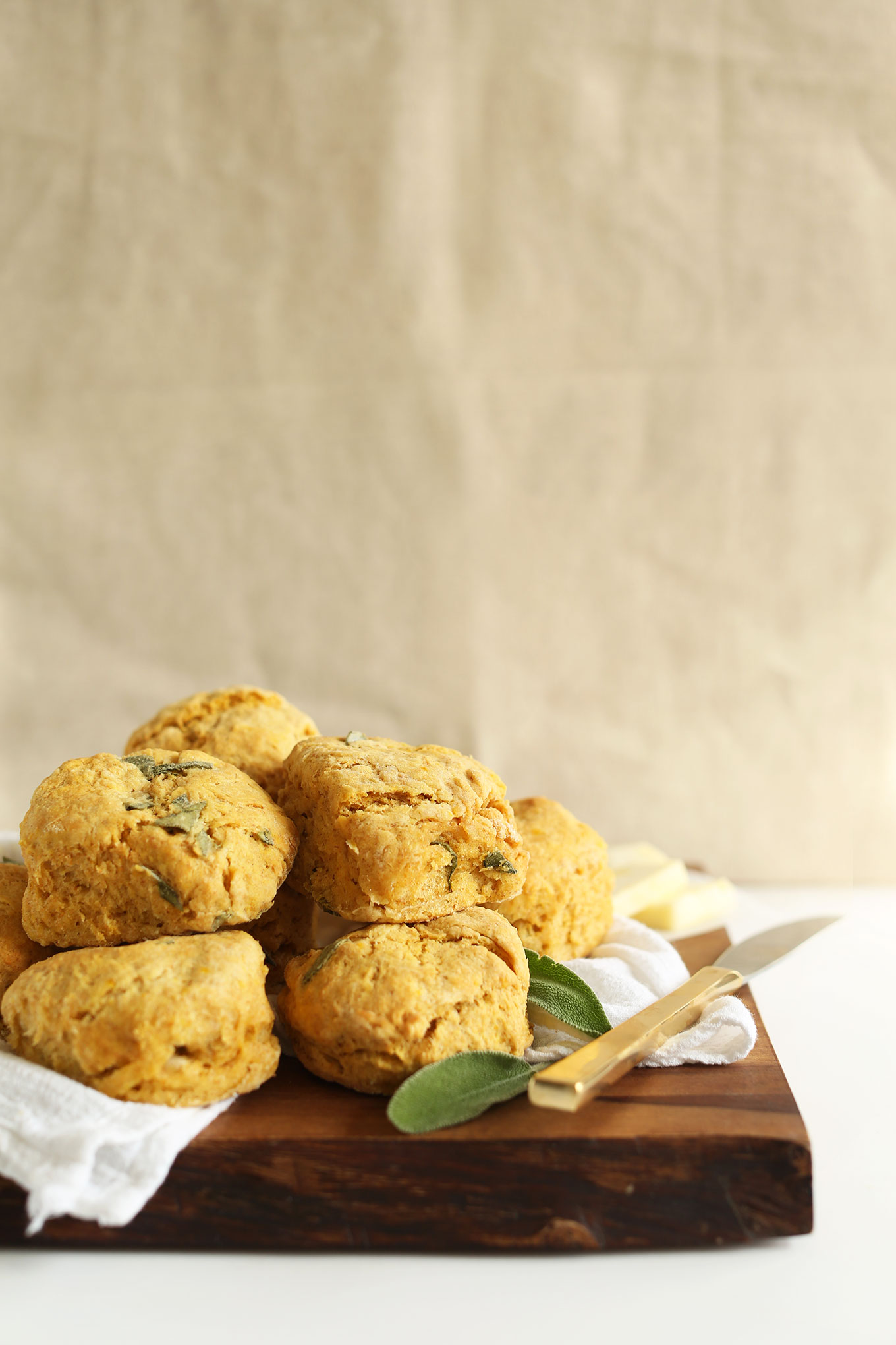 Stack of fluffy vegan Pumpkin Sage Biscuits resting on a cutting board