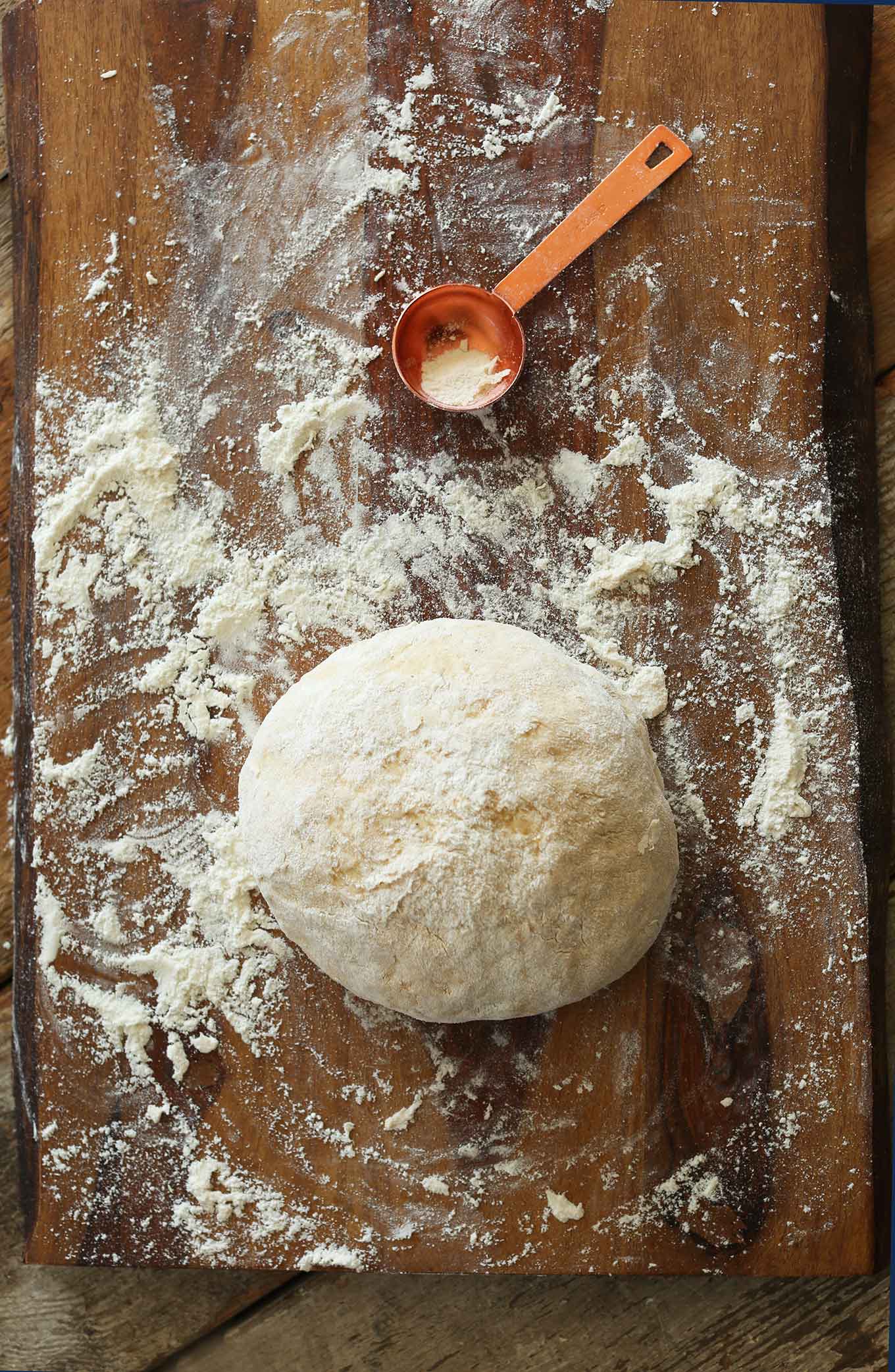 Cutting board with ball of floured dough for making Vegan Pumpkin Cinnamon Rolls