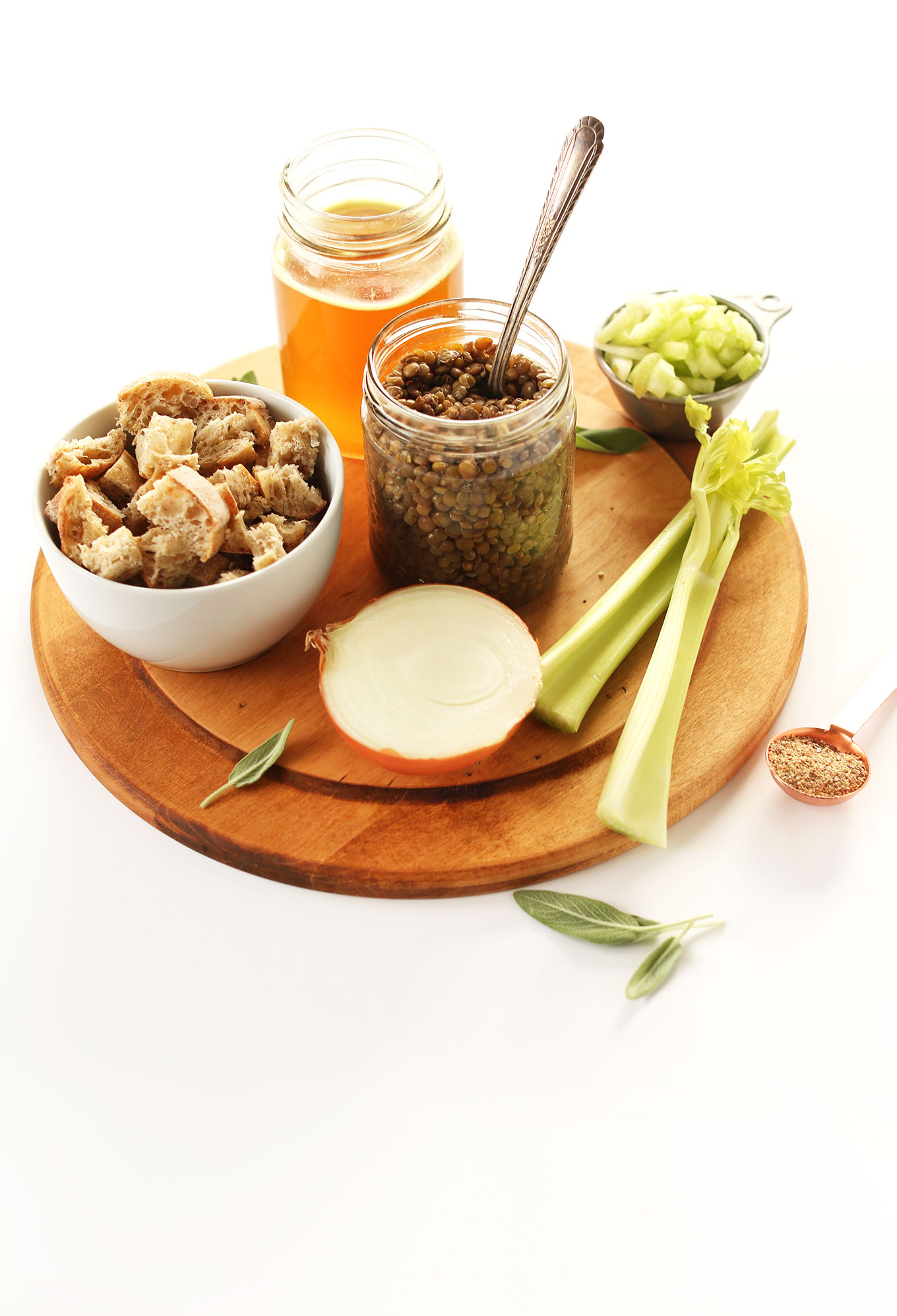 Cutting board with celery, onion, lentils, bread, and broth for making homemade vegan stuffing