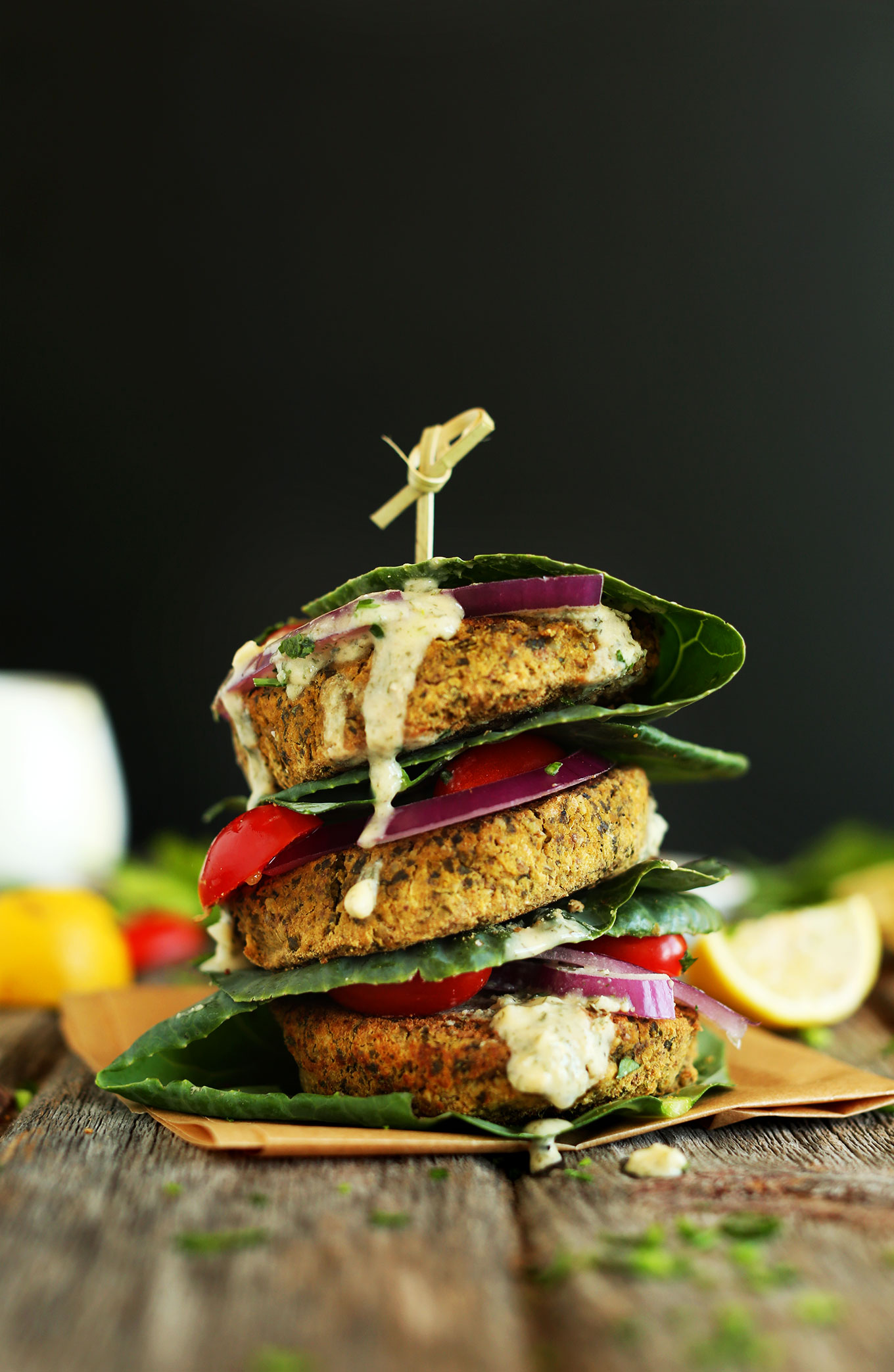 Stack of collard wrapped baked falafel burgers held together with a toothpick