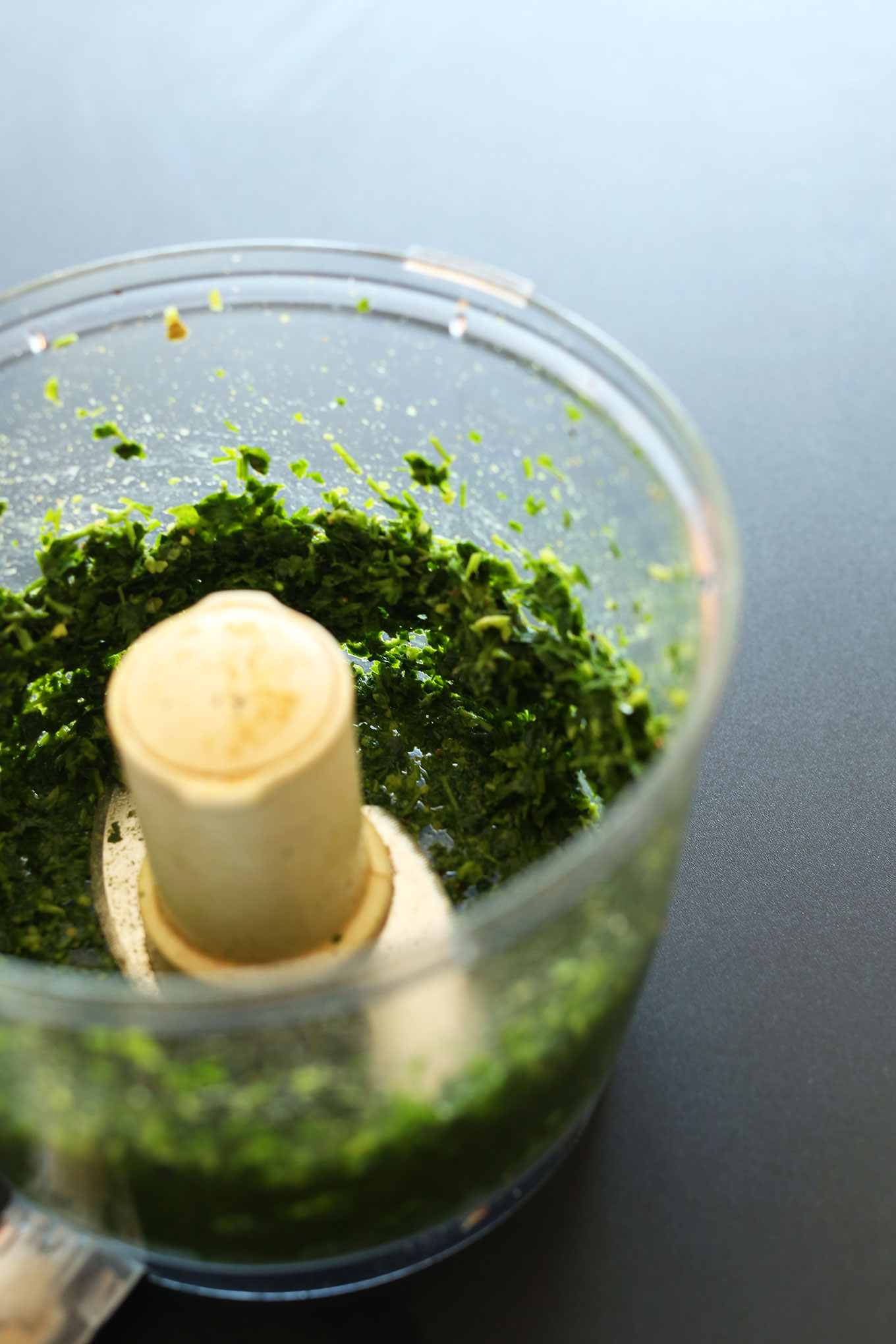 Pulsing green ingredients for falafel burgers in a food processor