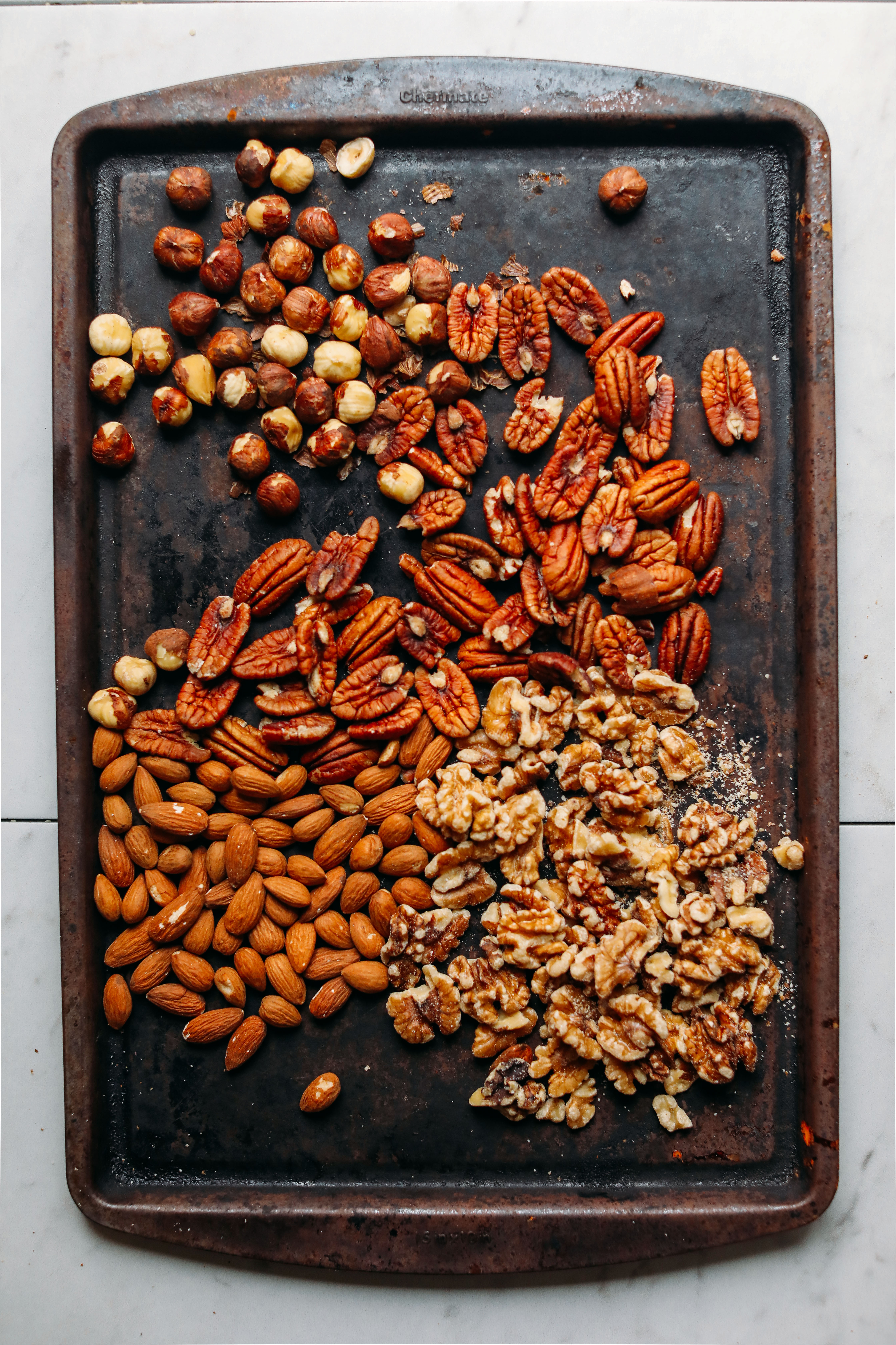 Baking sheet filled with nuts for making homemade nut butter
