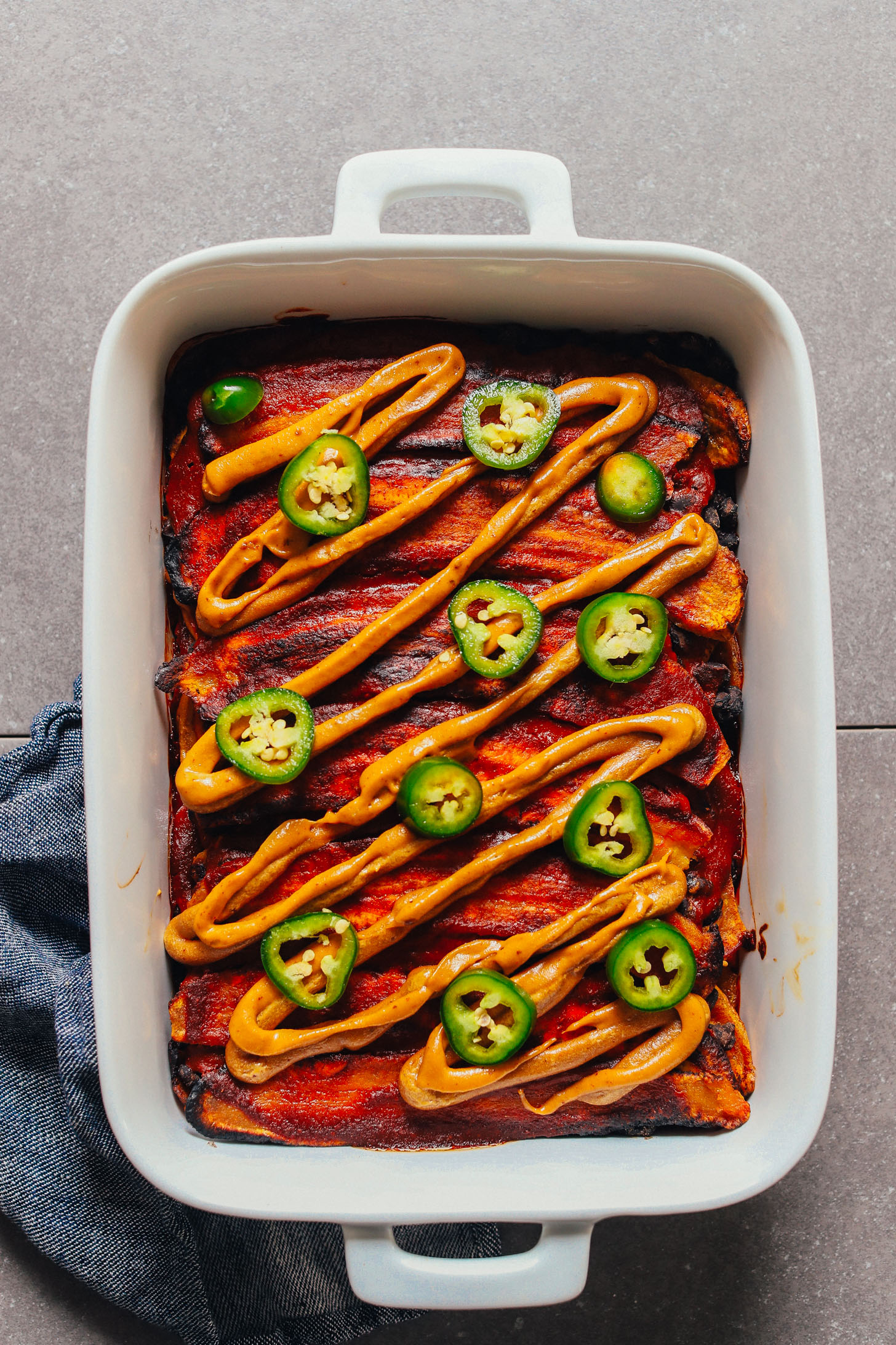 Baking dish filled with our recipe for Plantain Black Bean Enchilada Bake with Vegan Queso