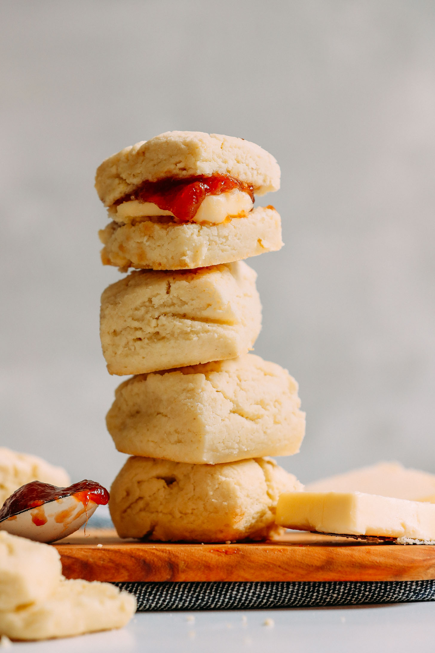 Stack of Vegan Gluten-Free Biscuits with the top biscuit filled with butter and jam