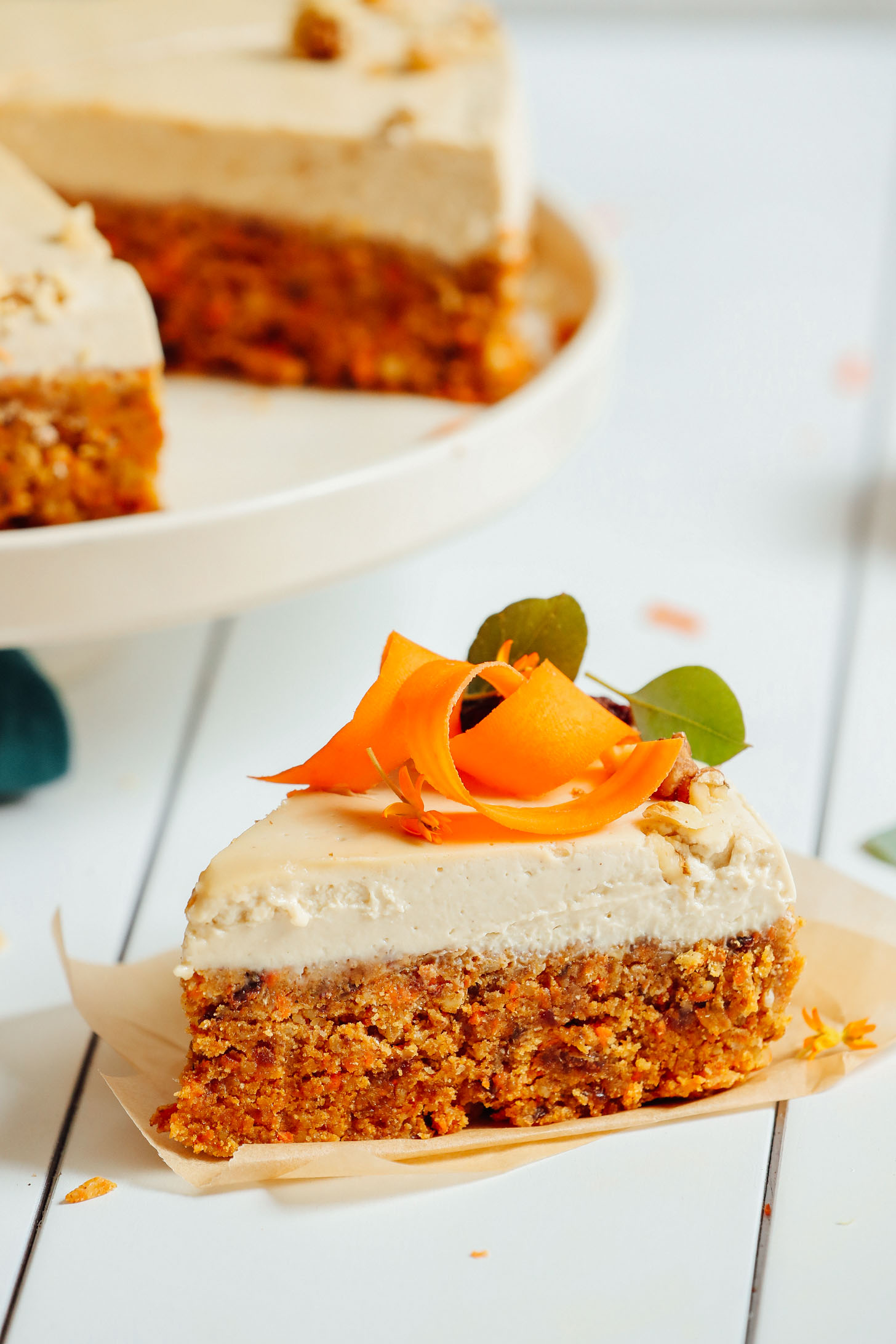 Close up shot of a slice of Raw Vegan Carrot Cake with vegan cream cheese frosting
