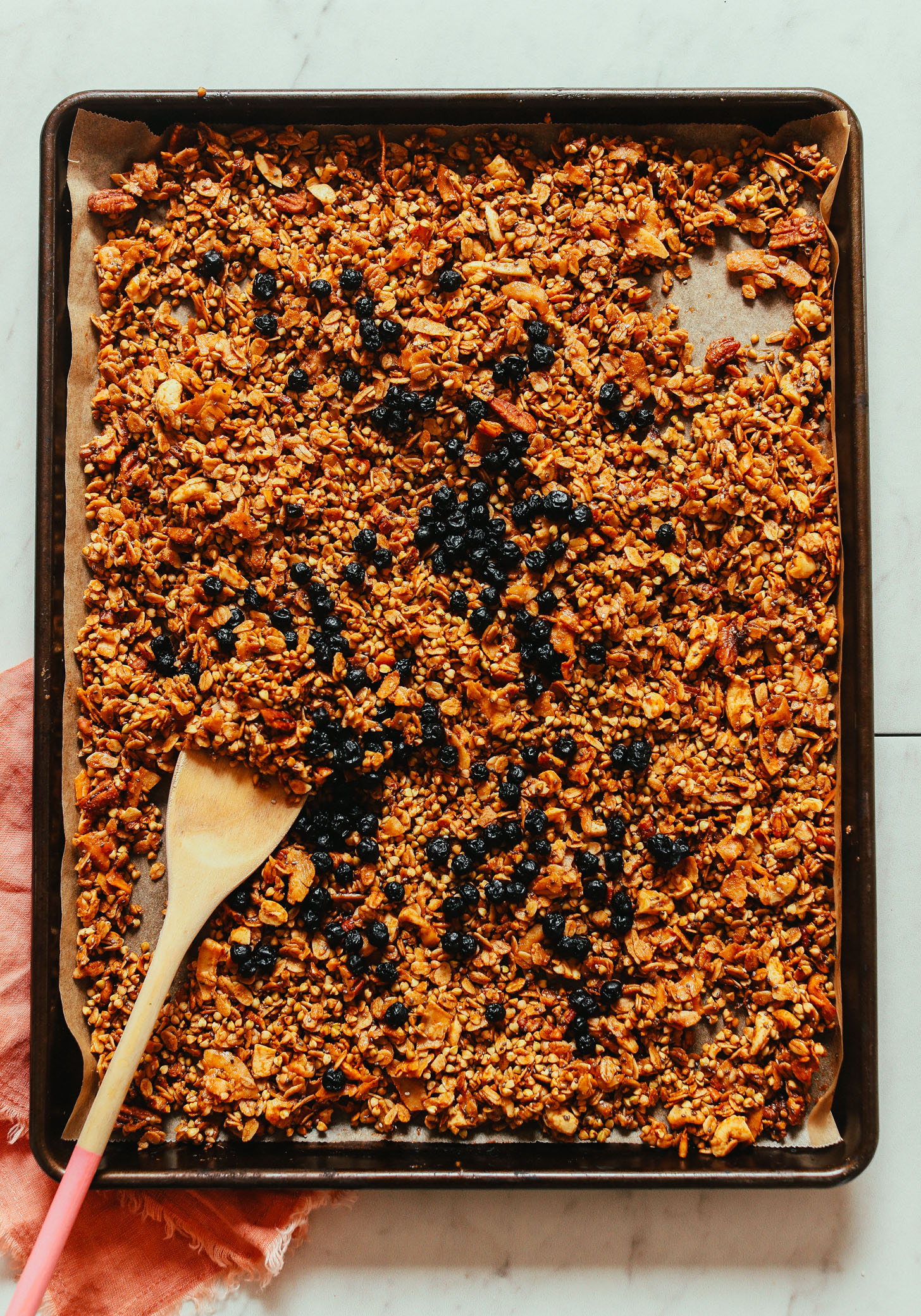 Freshly baked Easy Buckwheat Granola on a parchment-lined baking sheet