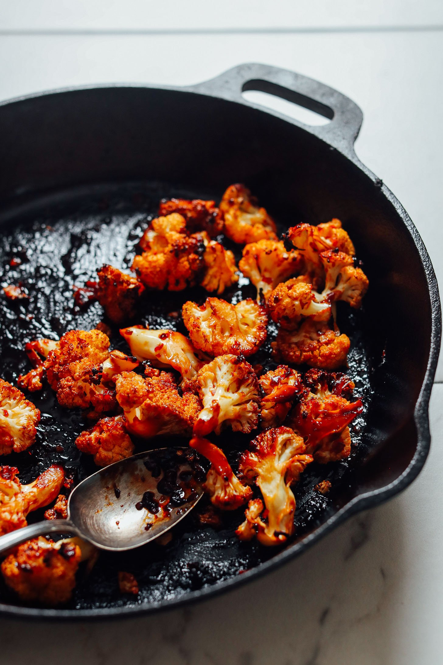Cooking cauliflower in a cast-iron skillet for delicious gluten-free vegan sandwiches