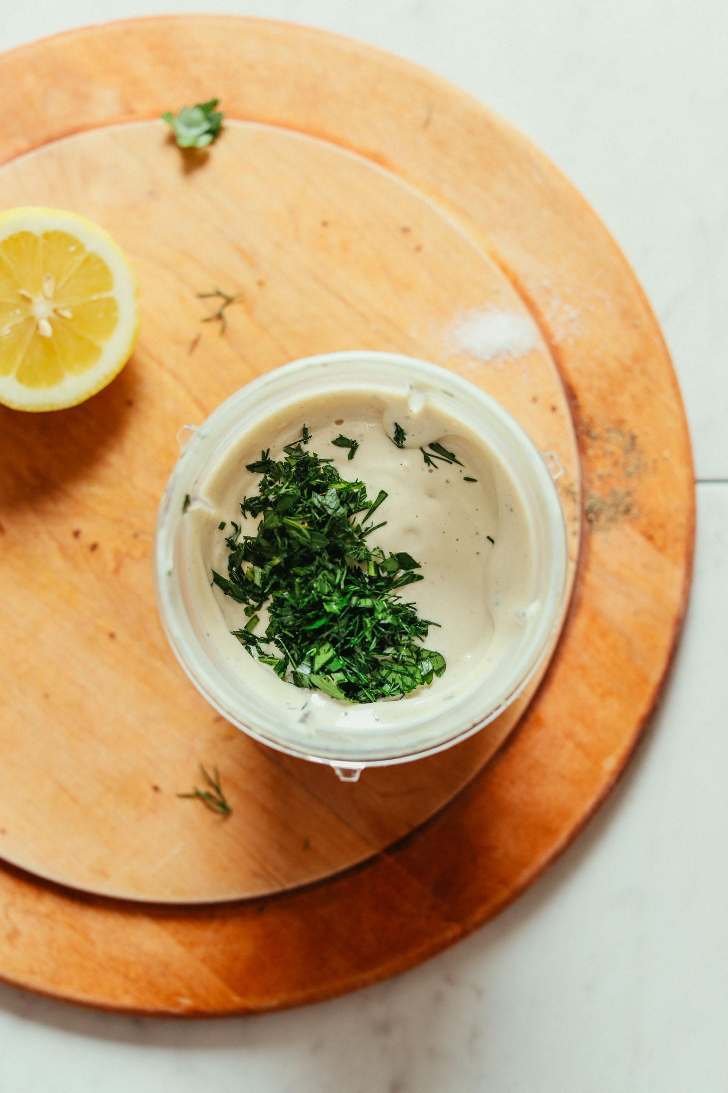 Small blender filled with Creamy Vegan Ranch decorated with fresh parsley