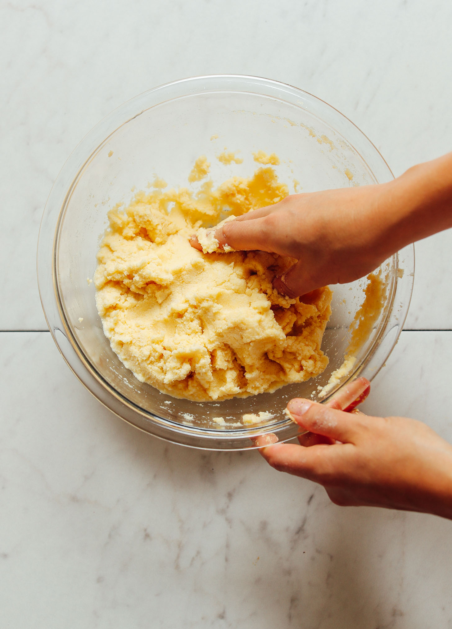 Mixing arepa dough by hand in a mixing bowl