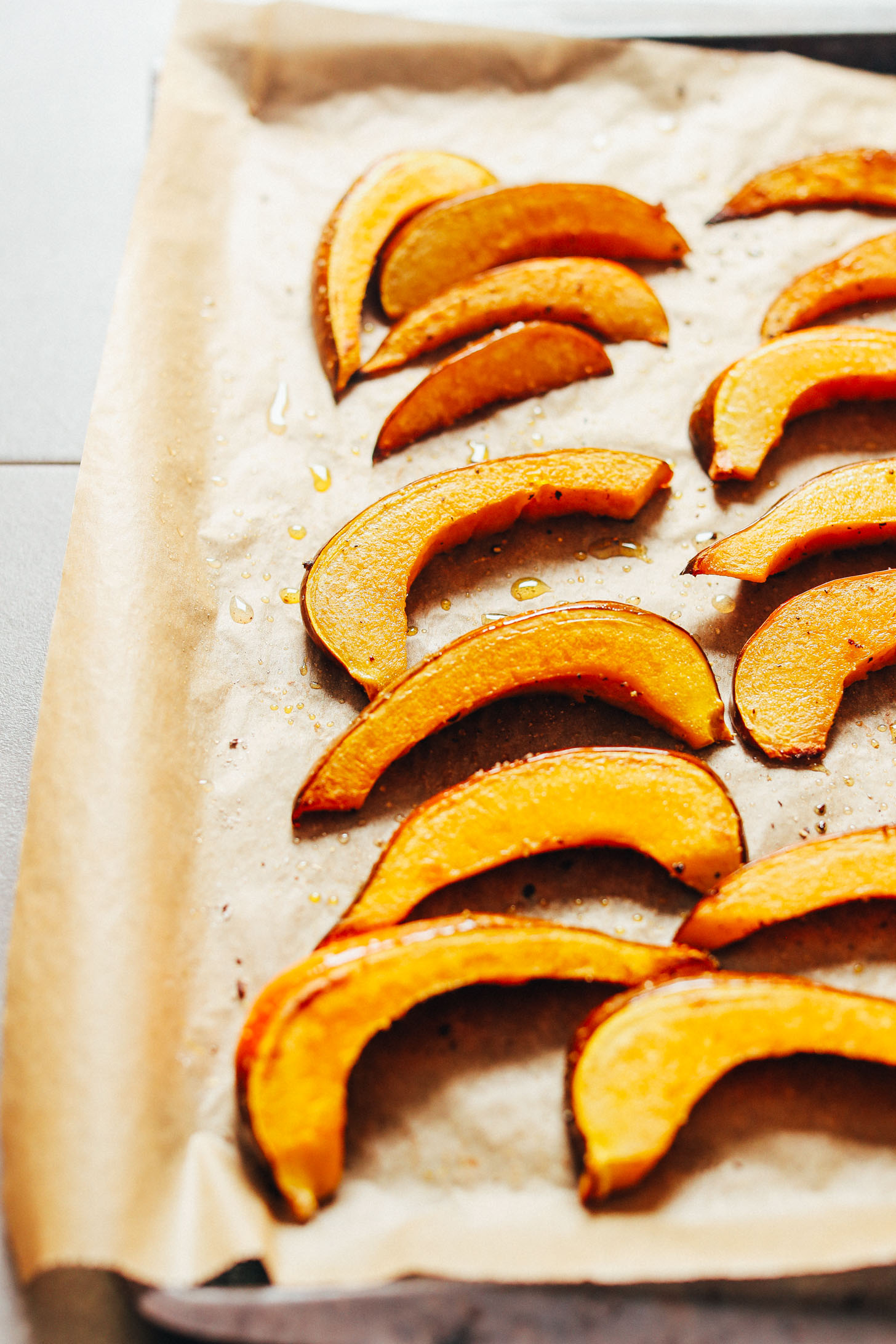 Roasted acorn squash slices on a parchment-lined baking sheet