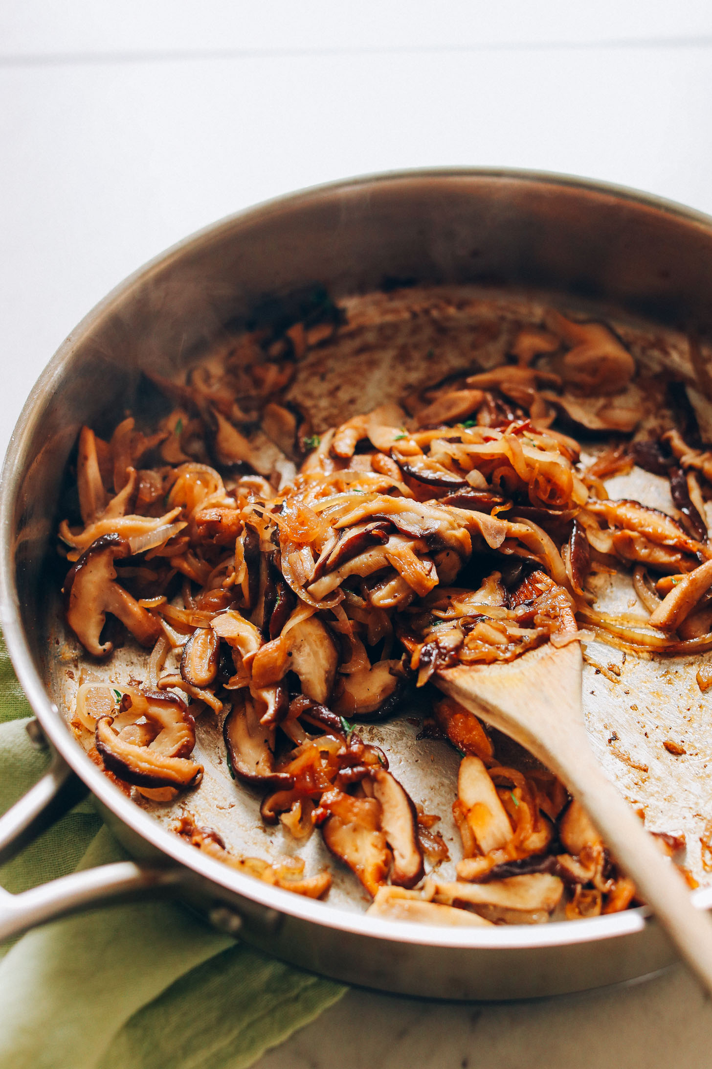 Skillet filled with Caramelized Shiitake Mushrooms and onions for homemade vegan risotto