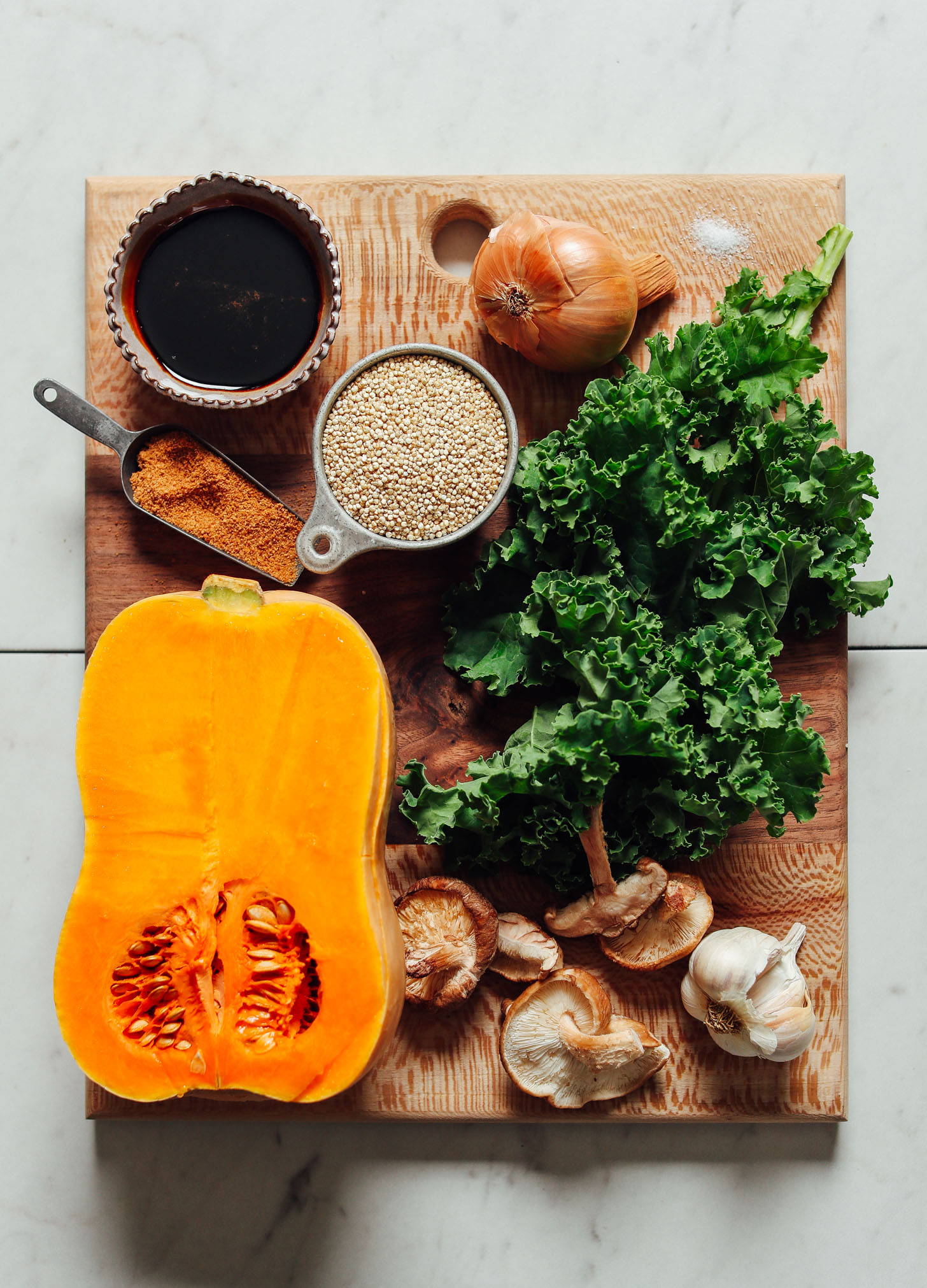 Cutting board with ingredients for making holiday stuffed butternut squash