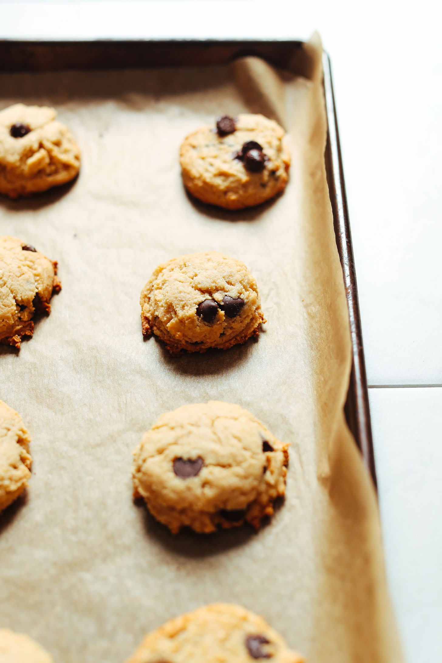 Parchment-lined baking sheet with a batch of Vegan Gluten-Free Chocolate Chip Cookies