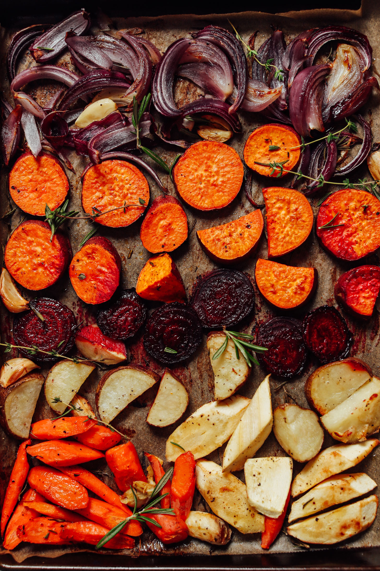 Baking sheet filled with freshly roasted vegetables and herbs for a simple vegan side dish