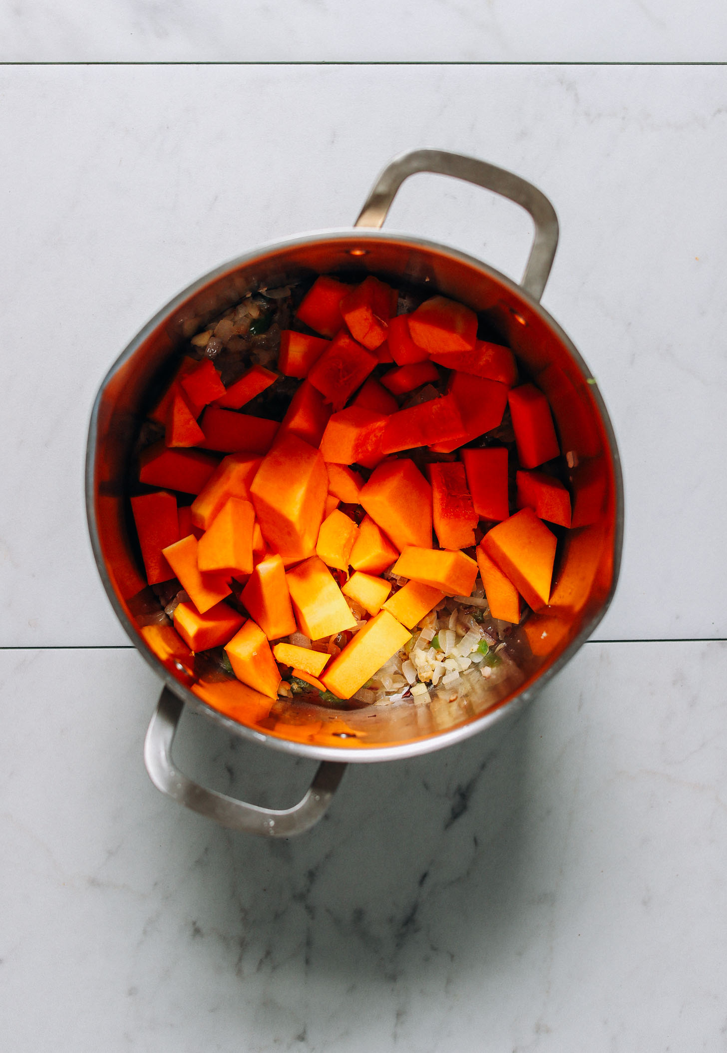 Butternut squash cubes added to a big pot of hearty vegan chili perfect for winter