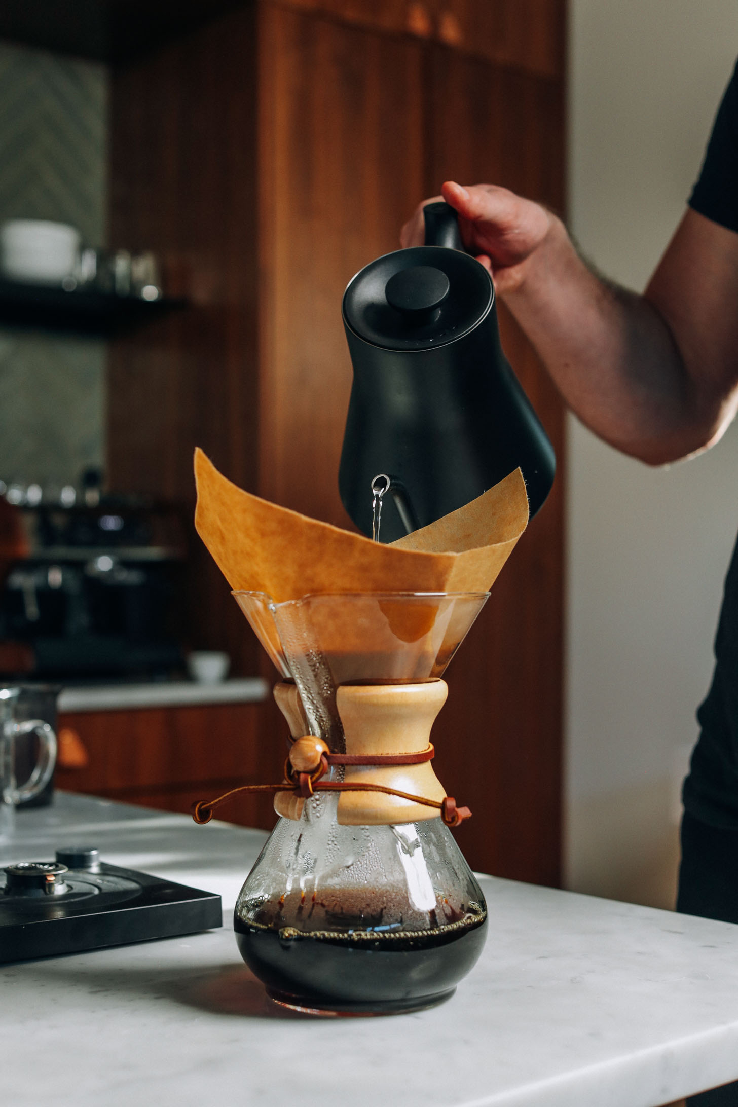 Pouring hot water through a coffee filter into a drip coffee maker