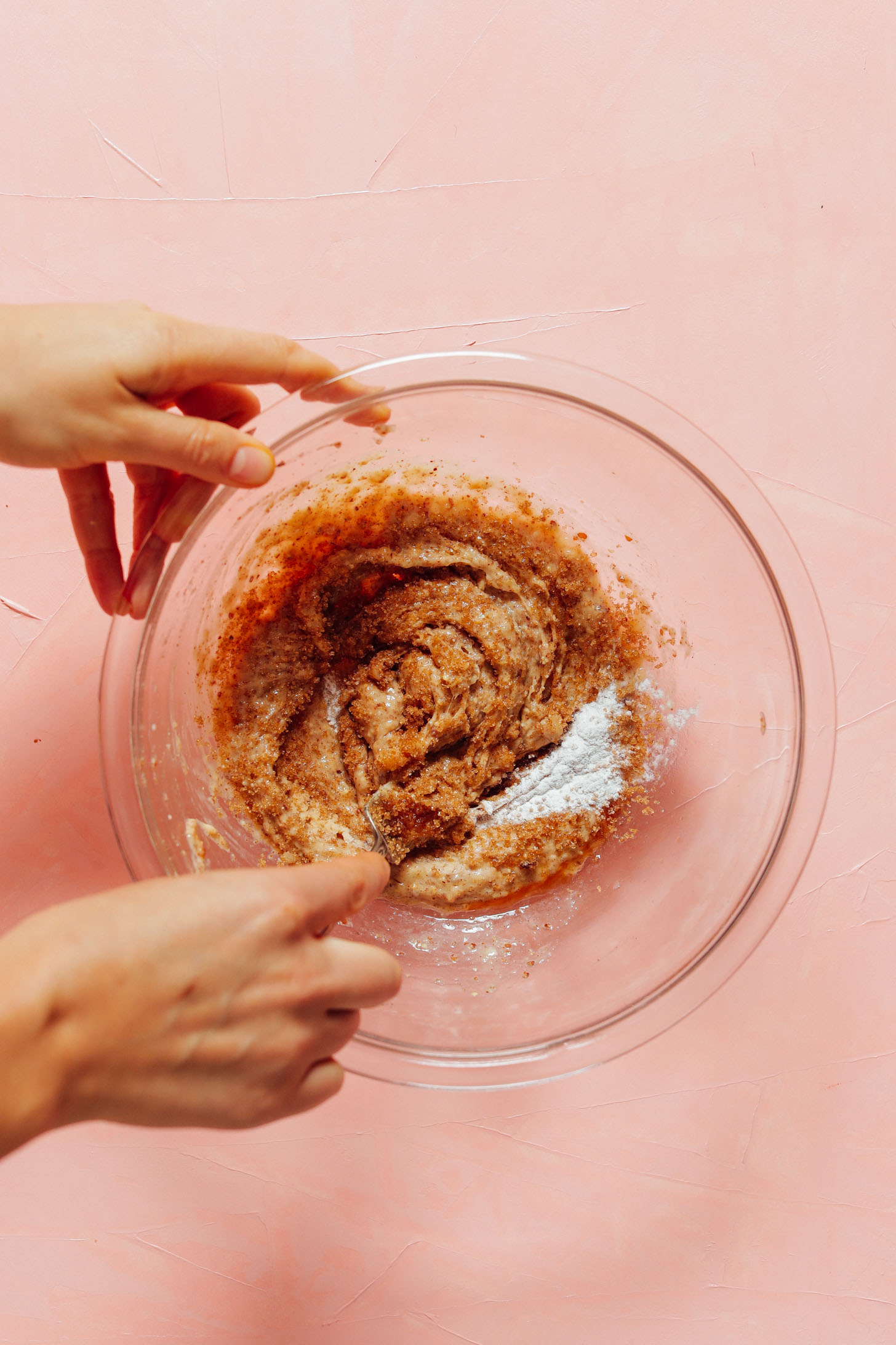 Stirring brown sugar, baking soda, and baking powder into gluten-free cookie dough batter