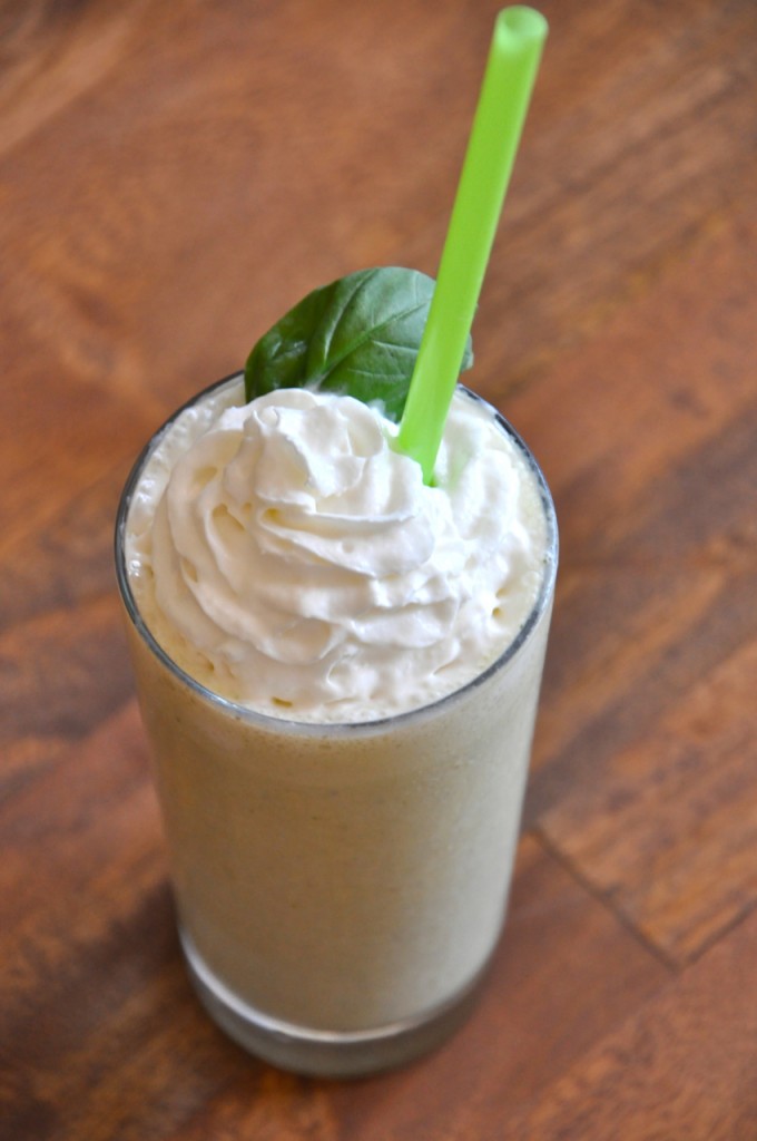 Tall glass of our Peanut Butter and Basil Milkshake recipe topped with fresh basil