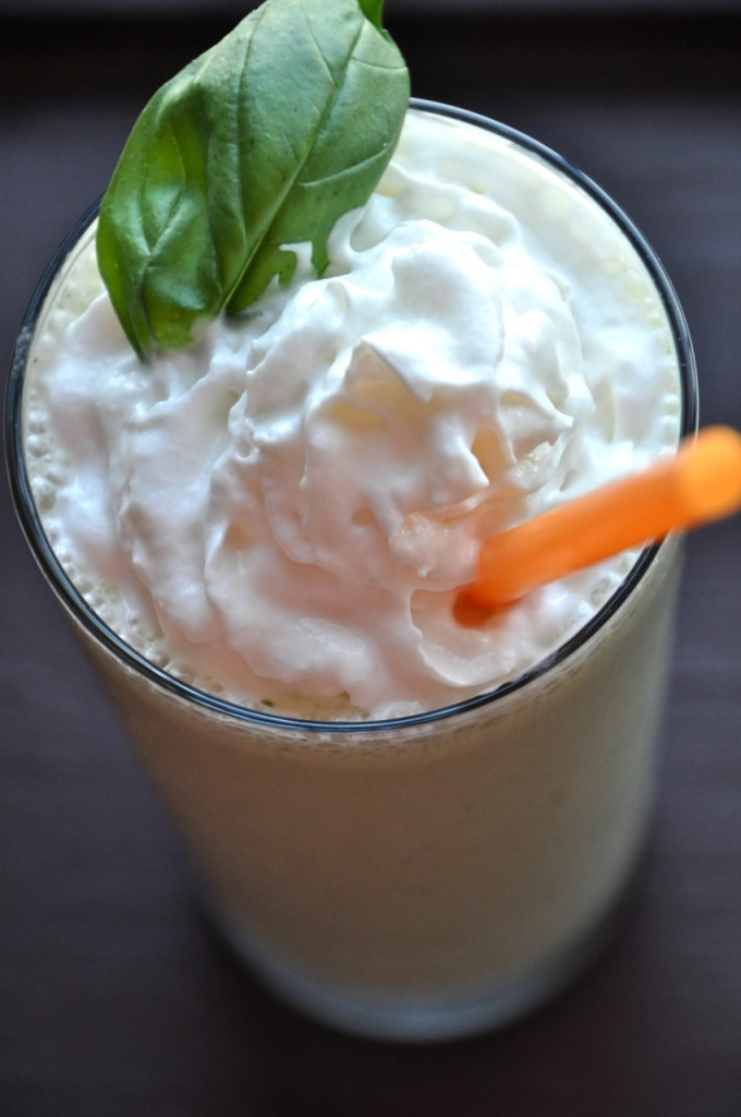 Tall glass of our Peanut Butter and Basil Milkshake recipe topped with whipped cream