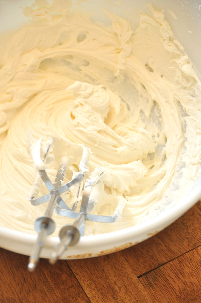 Using a hand mixer to whip up homemade Honey Buttercream Frosting
