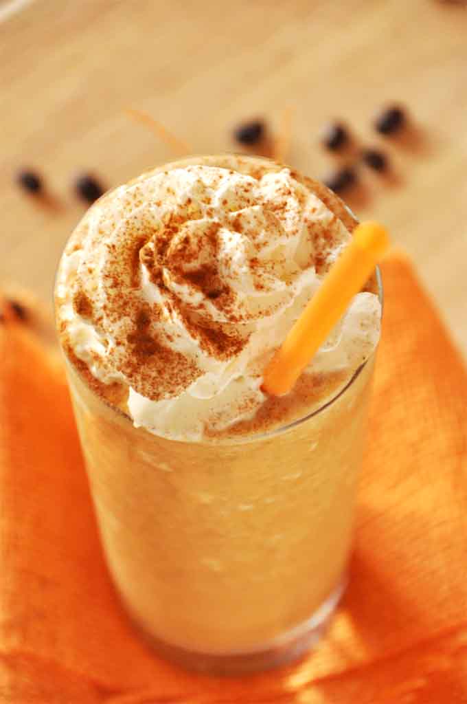 Tall glass of our homemade Pumpkin Frappuccino recipe topped with whipped cream
