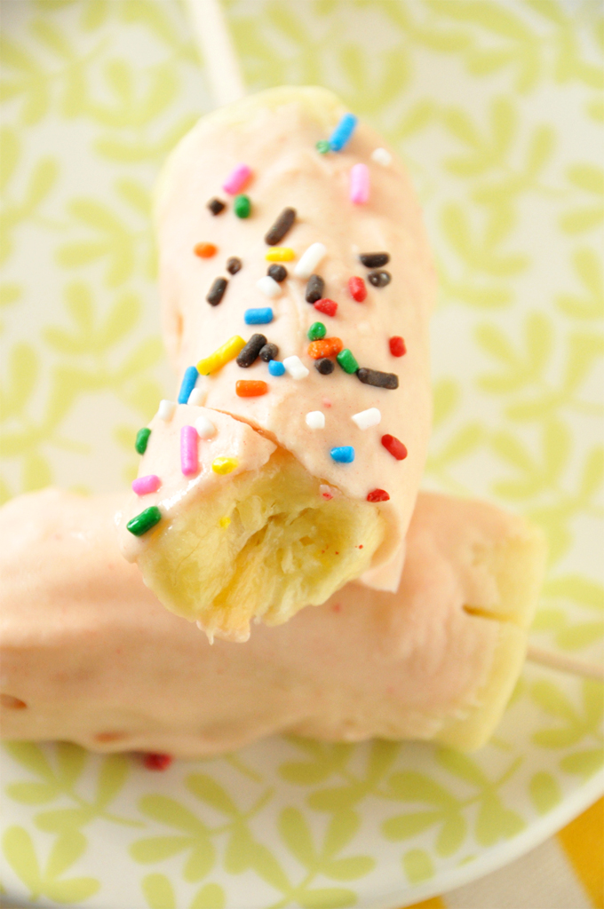 Banana pops coated in Strawberry Cake Magic Shell and rainbow sprinkles
