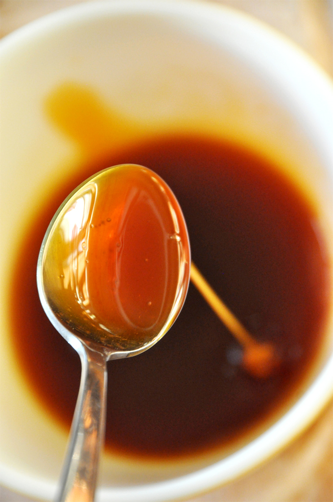 Holding up a spoonful of caramel sauce for making Vegan Snickers Pancakes