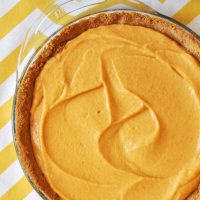Glass pie pan filled with our Creamy Pumpkin Pie recipe