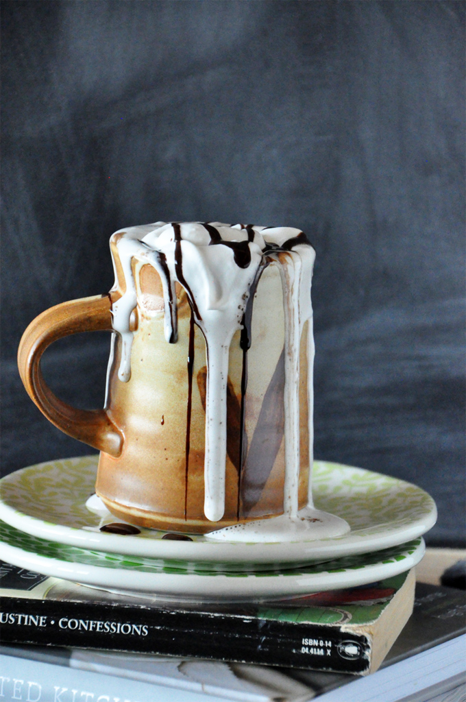 Tall mug filled with our Mexican Hot Chocolate recipe with coconut whipped cream flowing down the side