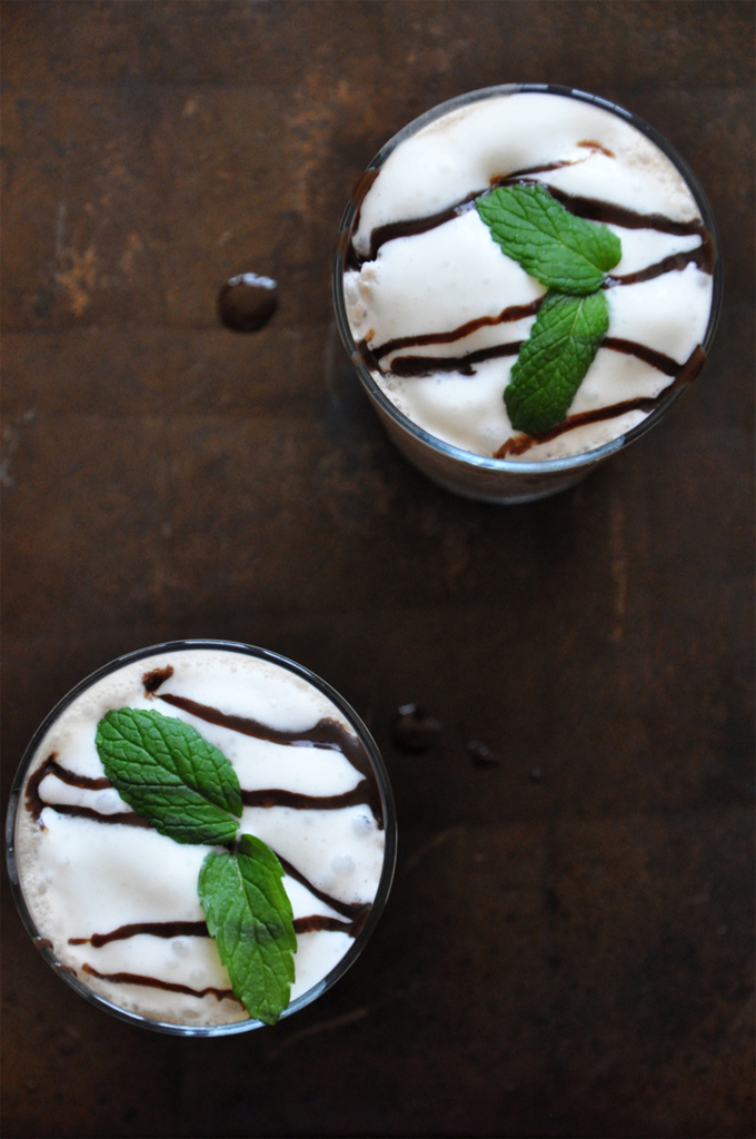 Baking sheet with glasses of Peppermint Mocha Frappe topped with whipped cream and mint leaves