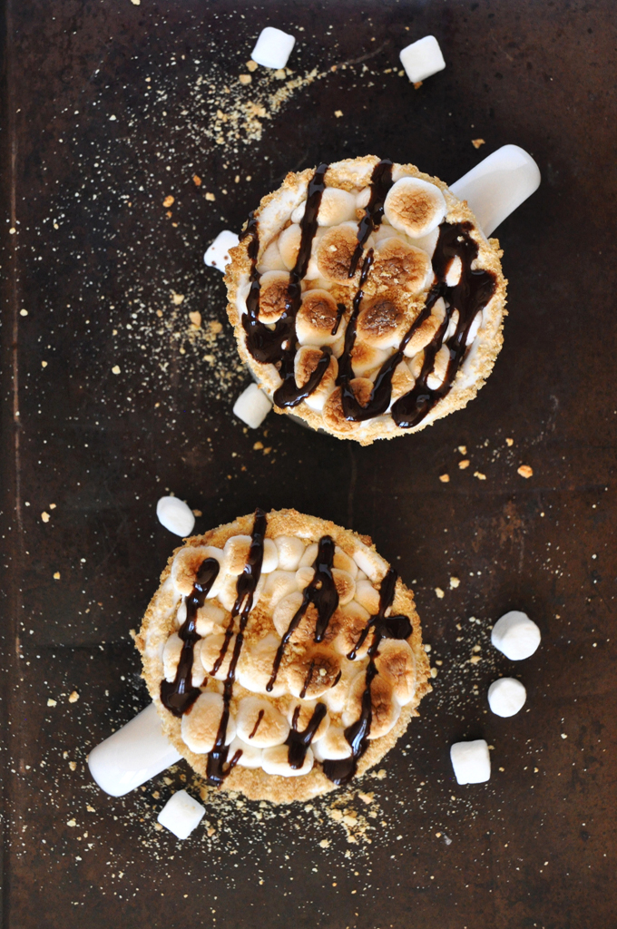 Mugs of S'mores Hot Chocolate topped with toasted marshmallows and chocolate sauce