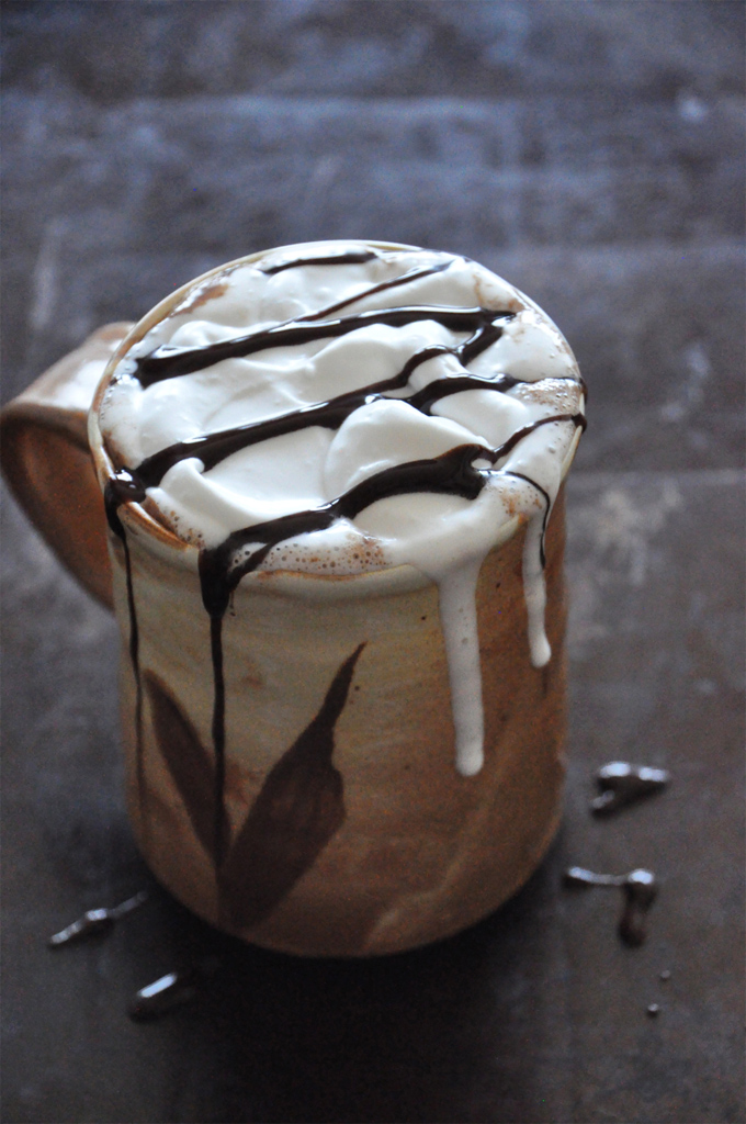 Mug of Mexican Hot Chocolate with Coconut Whipped Cream and a drizzle of chocolate syrup