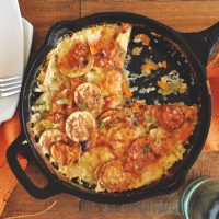 Skillet of Sweet Potato Parmesan Gratin with a slice removed