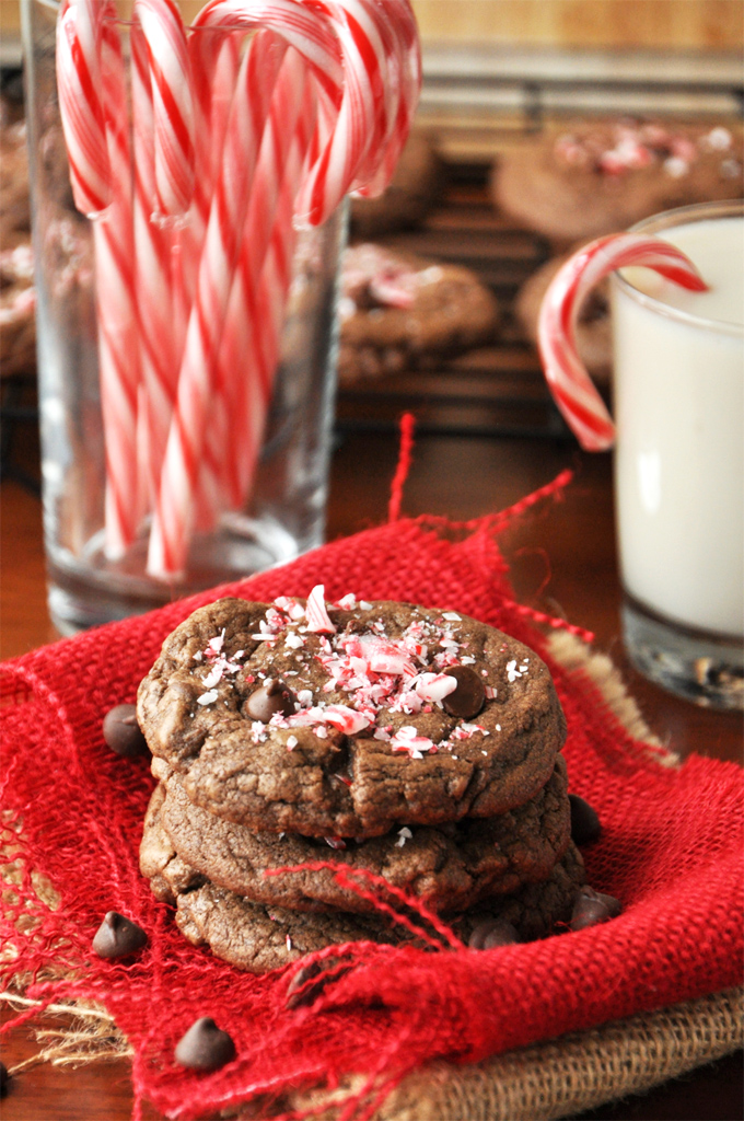 Stack of our Double Chocolate Peppermint Cookies recipe with milk and candy canes in the background