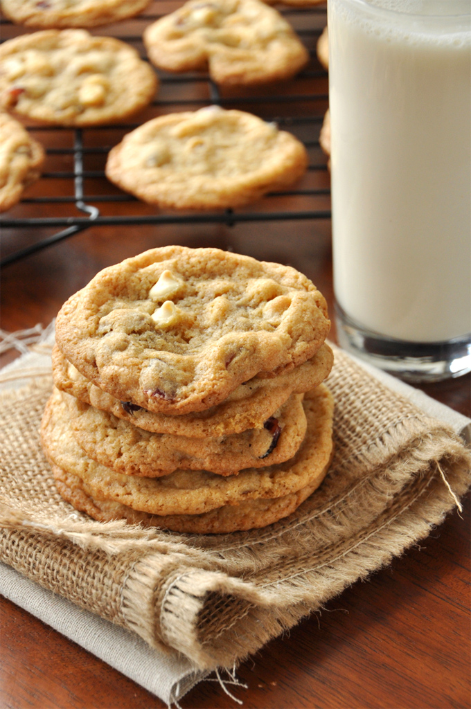 Stack of White Chocolate Cranberry Cookies alongside a glass of milk