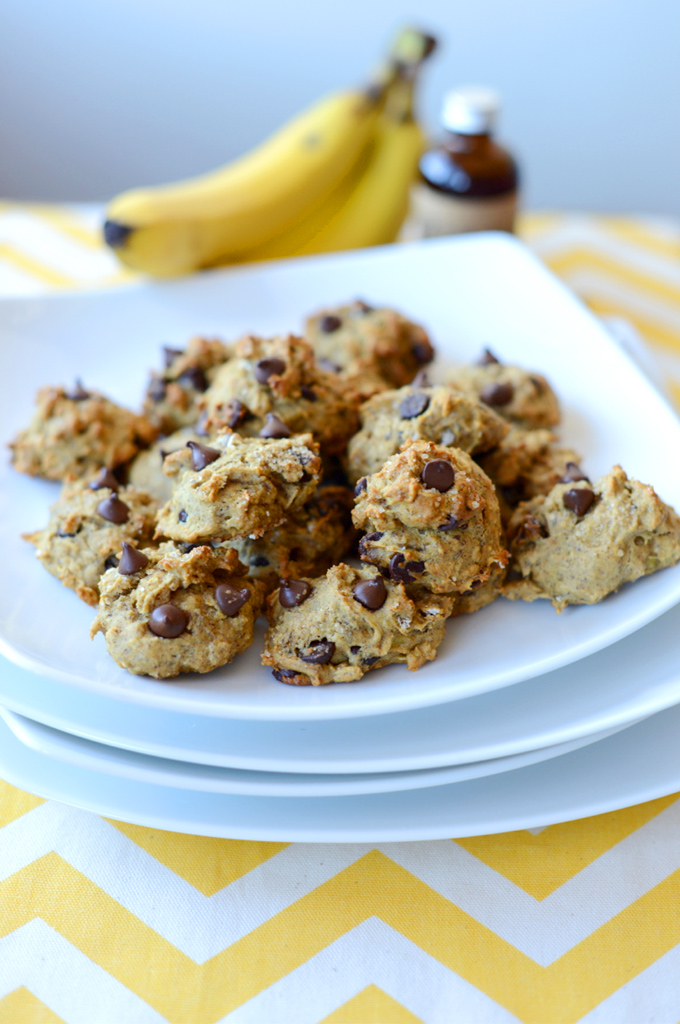 Plate of Chocolate Chip Banana Bread Bites with vanilla and bananas in the background