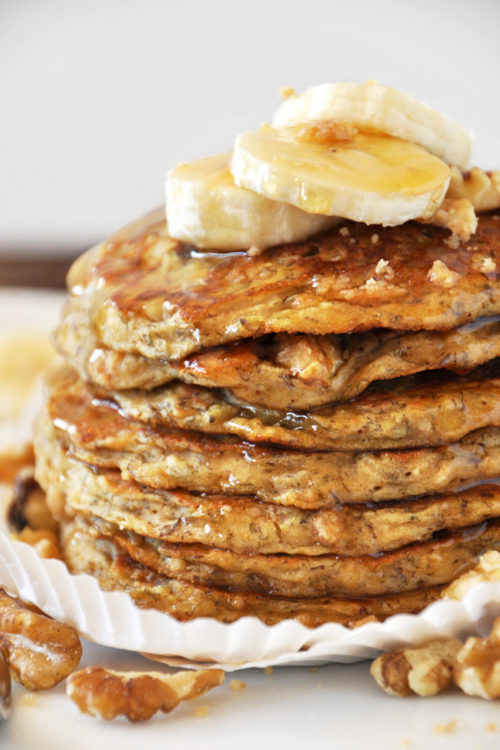 Close up shot of a batch of our Vegan Banana Nut Muffin Pancakes dripping with syrup