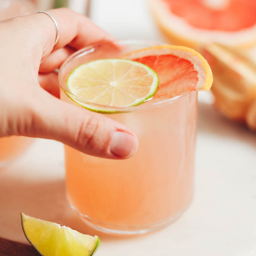 Hand picking up a grapefruit lime spritzer