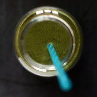 Top down shot of a straw in a jar filled with My Favorite Green Smoothie recipe