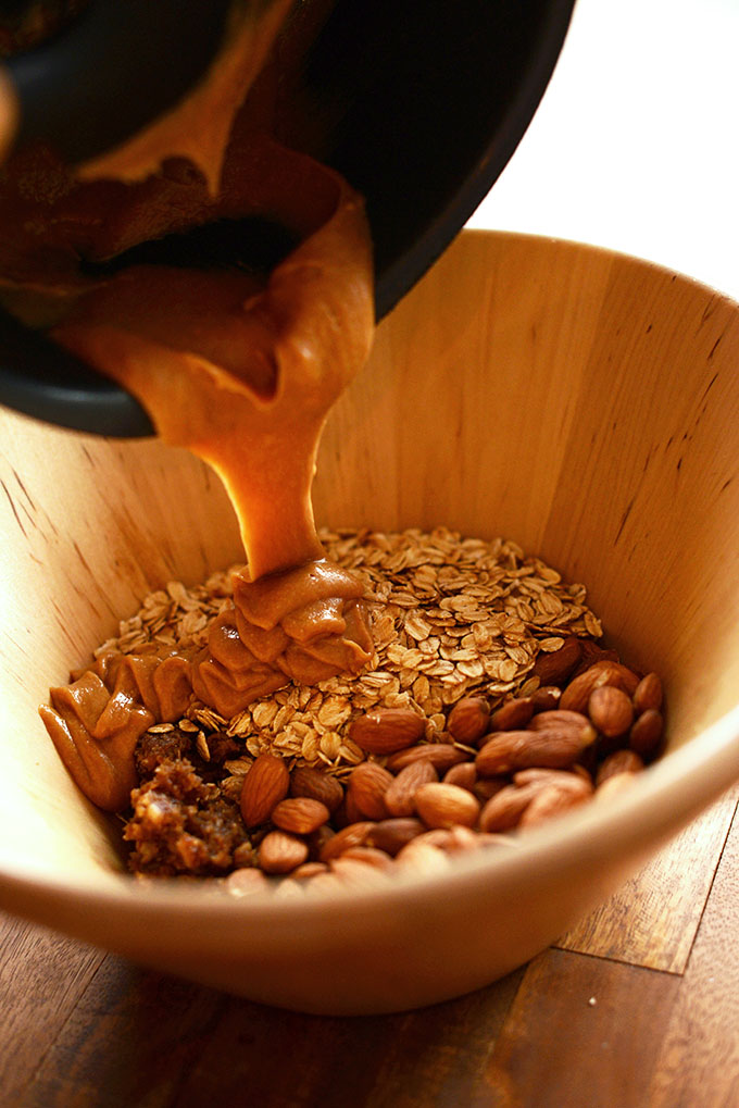 Pouring warm peanut butter honey mixture into dry ingredients
