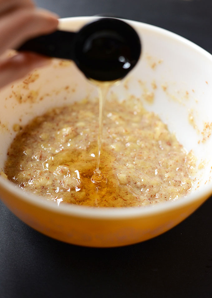 Pouring honey into a batch of our Banana Muffin batter